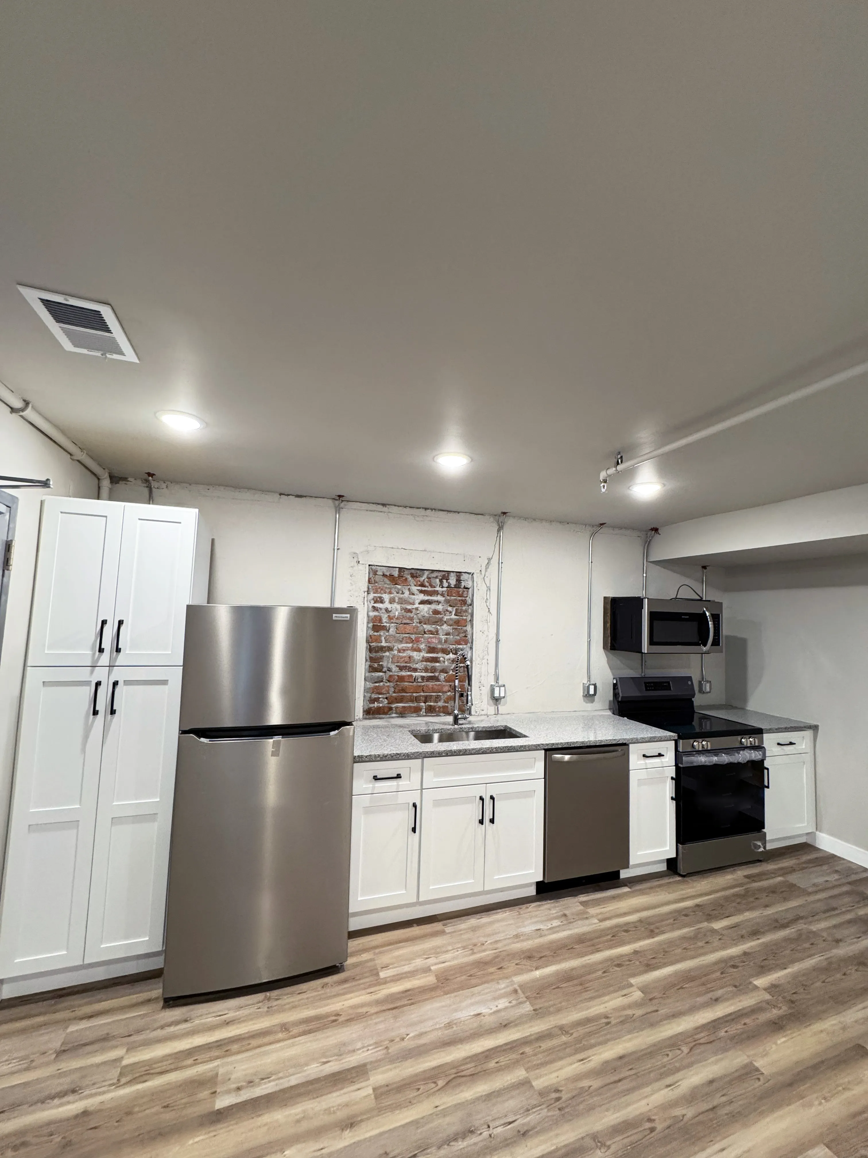 Furnished loft Unit 1 with exposed brick and high ceilings - Brick & Beam Lofts, Columbus Park, Kansas City